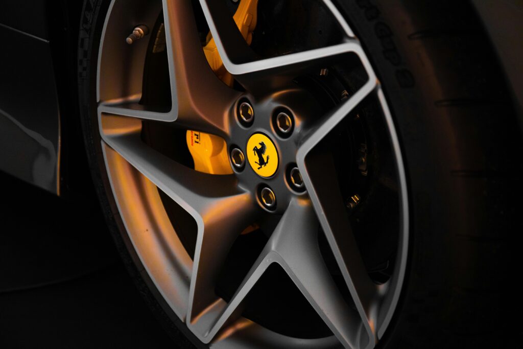 Detailed close-up image of a luxury car wheel featuring a metallic rim and distinctive logo.